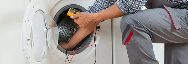 Dryer repair technician inspecting and repairing a clothes dryer in Tampa, FL