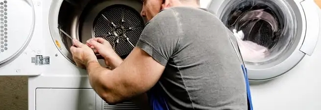 Dryer repair technician fixing a clothes dryer drum in Tampa, FL