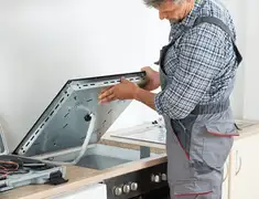 Appliance repair technician installing a built-in cooktop in Tampa, FL