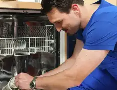 Dishwasher repair technician inspecting and servicing an open dishwasher in Tampa, FL
