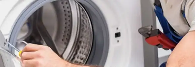 Appliance technician repairing a clothes dryer drum and internal parts in Tampa, FL