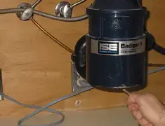 Garbage disposal repair technician tightening the mounting ring under a sink in Tampa, FL