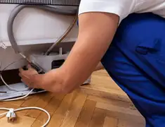 Appliance repair technician fixing refrigerator water line and connections in Tampa, FL