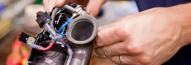 Vacuum repair technician reconnecting wiring and components in Tampa, FL
