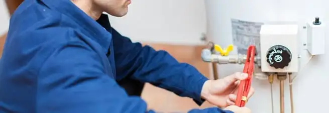 Water heater repair technician adjusting the temperature control and gas valve in Tampa, FL